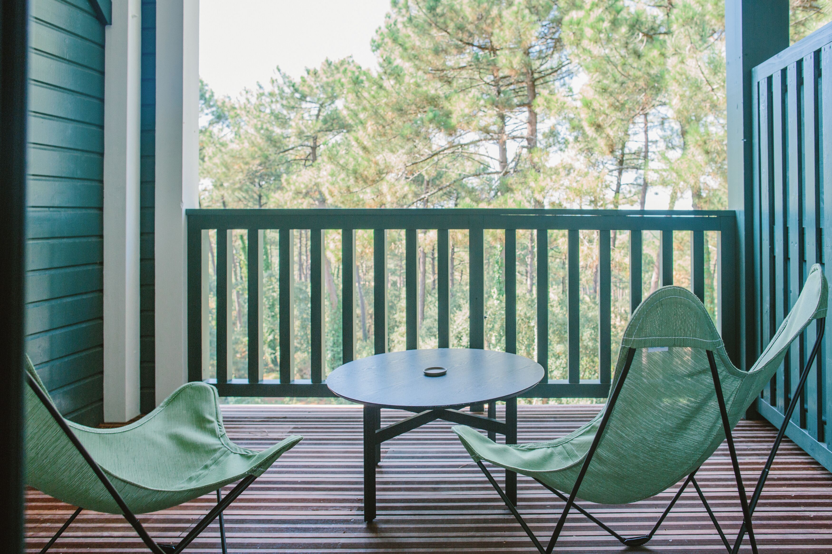 A covered outdoor seating area with a table and two chairs.