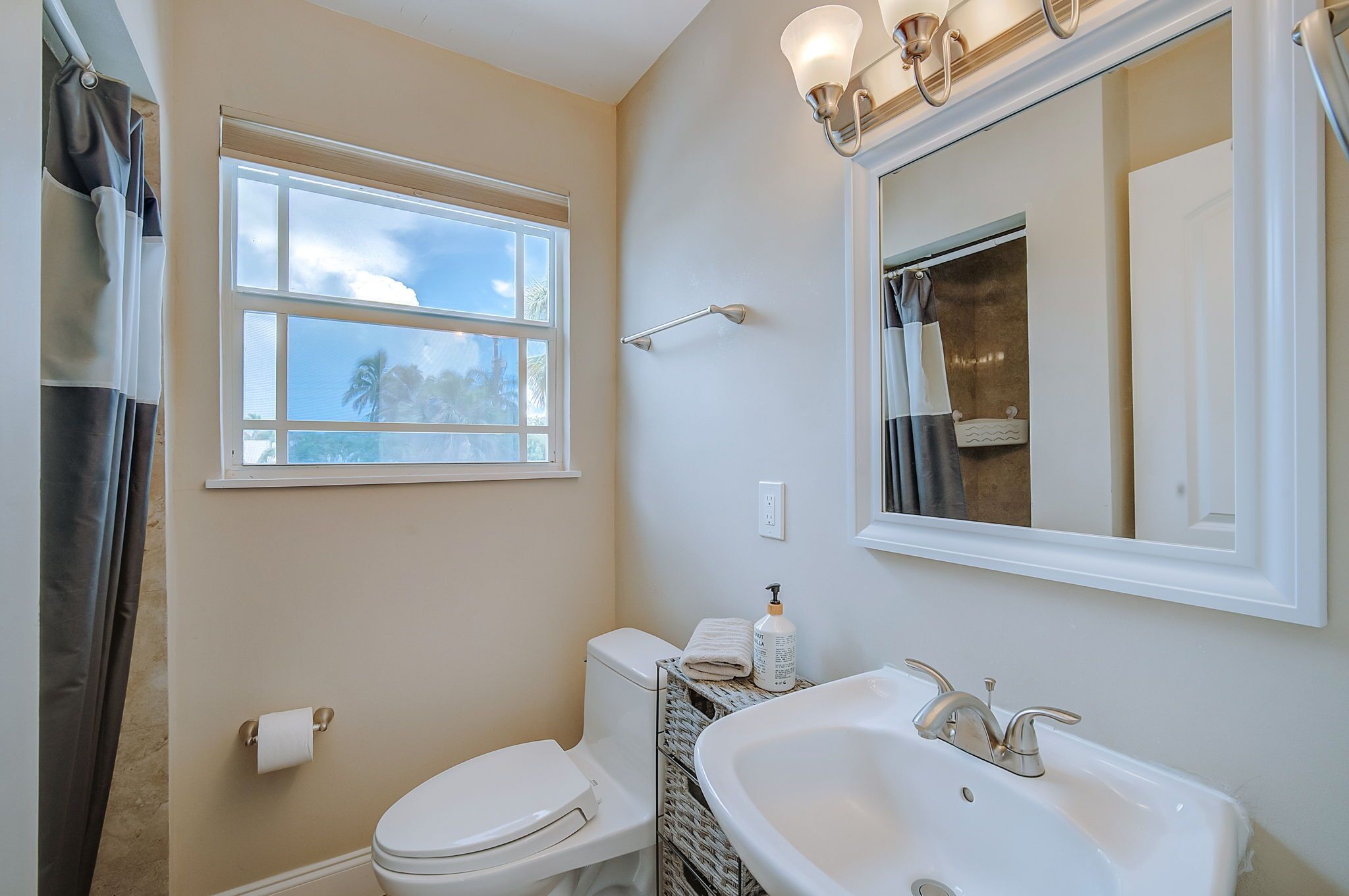Ein Badezimmer mit Toilette, Waschbecken und Fenster.