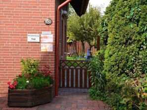 A brick building with a sign indicating free parking. - Sea time. Newly renovated apartment with garden in a quiet, central residential area (Norden)