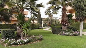 A well-maintained garden with palm trees, manicured lawns, and flower beds. - Center La Cala De Mijas, penthouse,terrace 100 m², near beach and town center (LA CALA DE MIJAS)