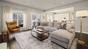 A living room with a sectional sofa, a coffee table, a chair, and a floor lamp.