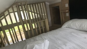 A hotel room with a bed, white linens, and a wooden partition. - 2 Bed Lodge - Sleeps 4 - Parking - Wifi (Inverness)