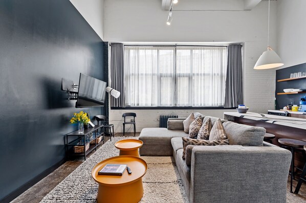 Ein modernes Wohnzimmer mit Sofa, Couchtisch und Fernseher.