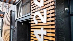 Fachada de edificio con un cartel grande que dice 'Gold Way'.