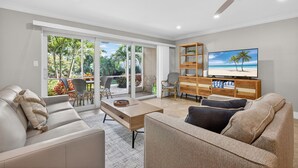 Ein modernes Wohnzimmer mit einer Couch, einem Couchtisch und einem TV-Schrank.
