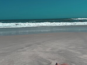 A beach with a clear sky and waves.