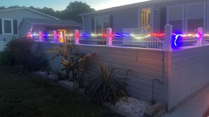 A house with a covered porch decorated with colorful lights. - 2 BR 1 BA Dog friendly home in Assateague Pointe WOC: Text BEFORE booking!! (Berlin)