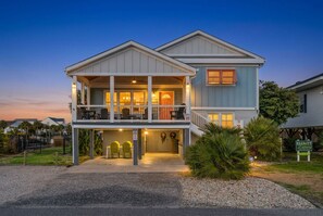 A two-story house with a balcony, a garage, and a driveway. - Channel Your Inner Beach, Channel House in Cherry Grove with Fantastic Views (North Myrtle Beach)