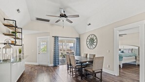 Una cocina amplia con comedor, ventilador de techo y vistas al exterior.