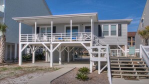 A two-story house with a covered porch and a small garden area. - Summer Rates Reduced at Magnificent Surf (North Myrtle Beach)