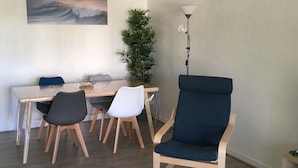 A dining area with a table, chairs, a potted plant, and a lamp. - T3 3* apartment in the heart of Anglet, a few minutes from the beaches (Anglet)