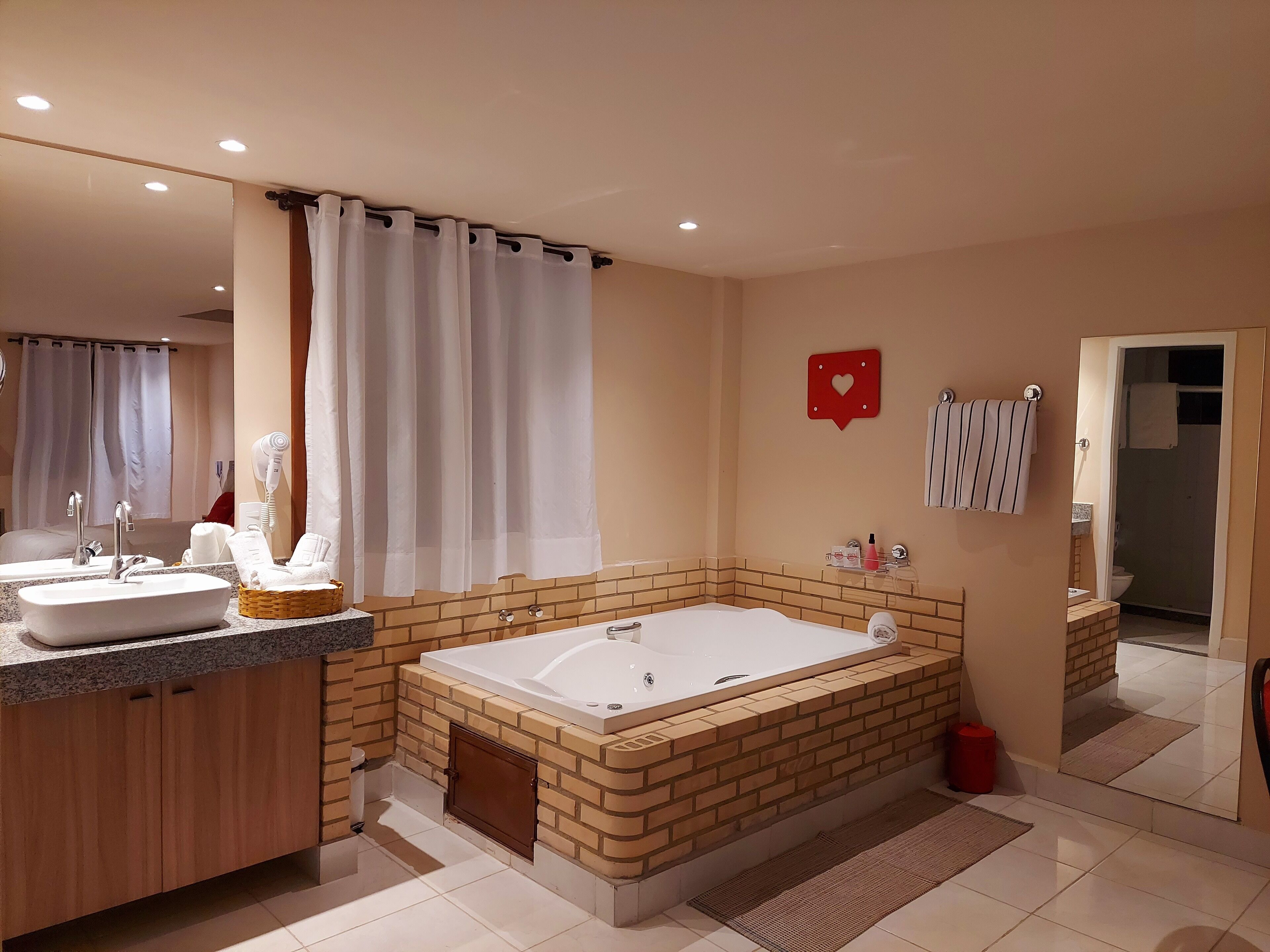 Un baño moderno con una bañera grande, dos lavamanos, ducha y tocador con espejo.