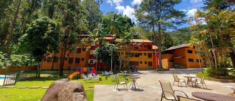 A resort with colorful buildings, outdoor seating, and a playground.