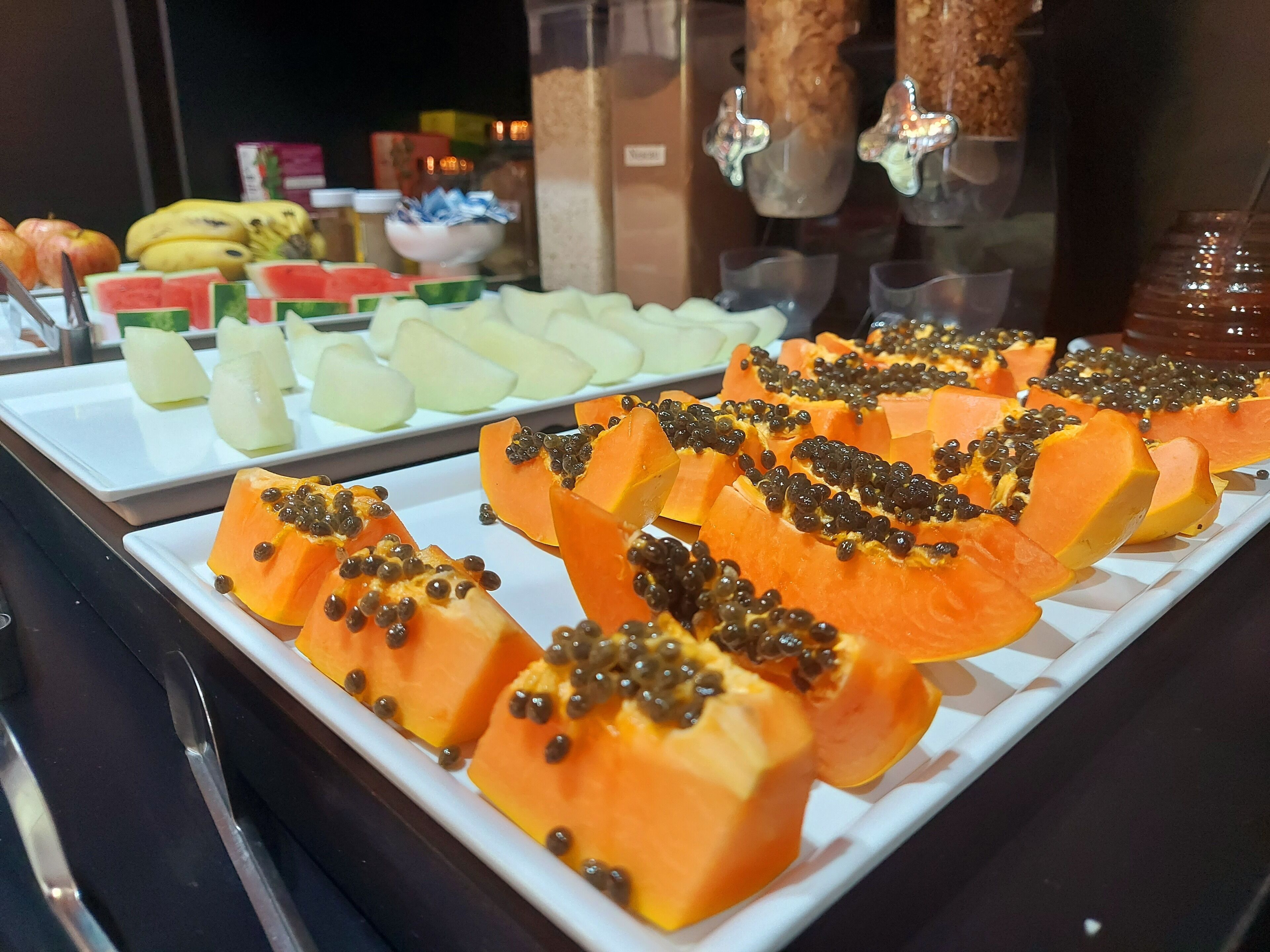A buffet with various fruits including papaya and watermelon.
