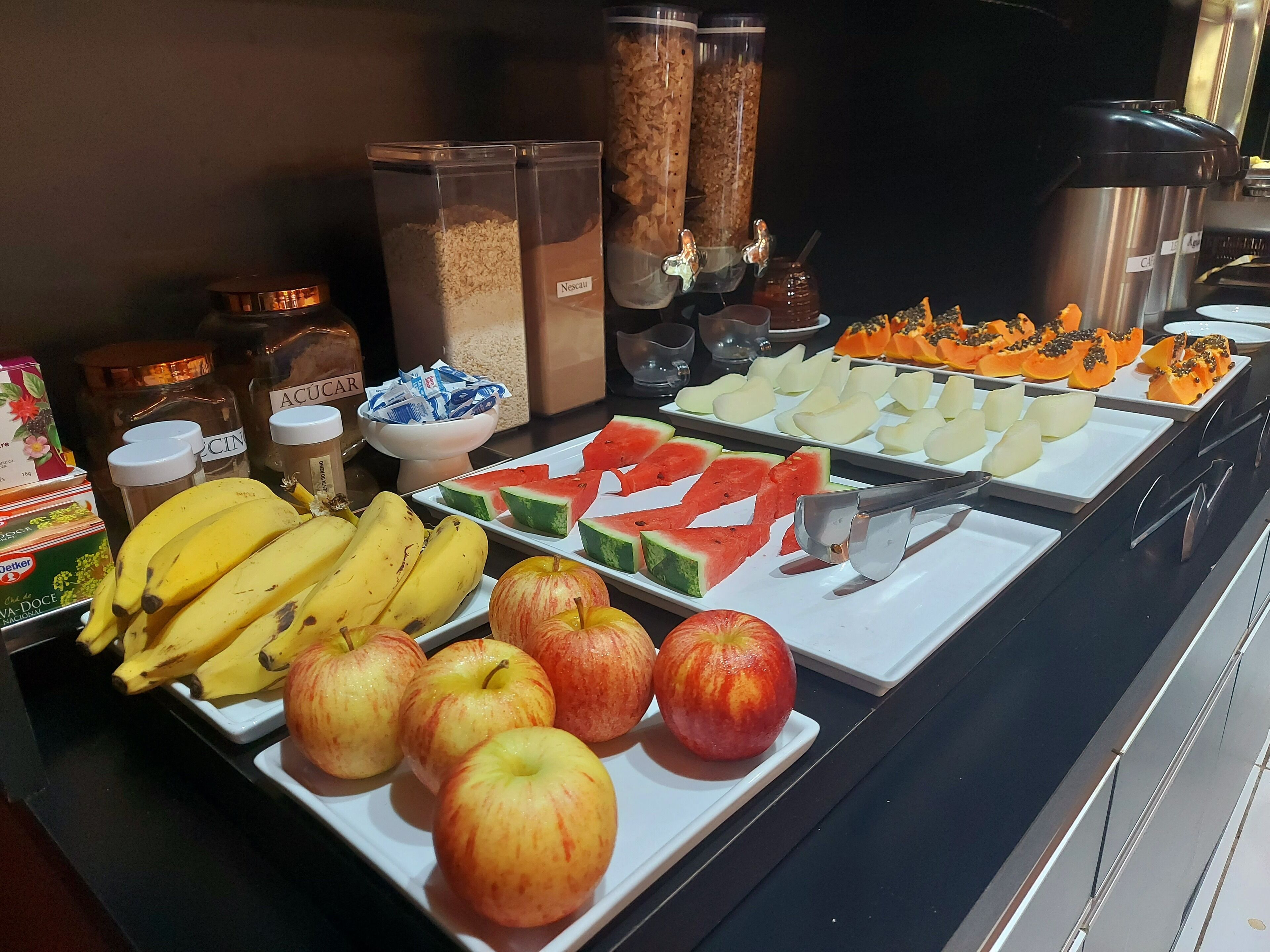 Een buffet met verschillende soorten fruit en bijbehorende sauzen.