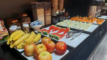 Een buffet met verschillende soorten fruit en bijbehorende sauzen.
