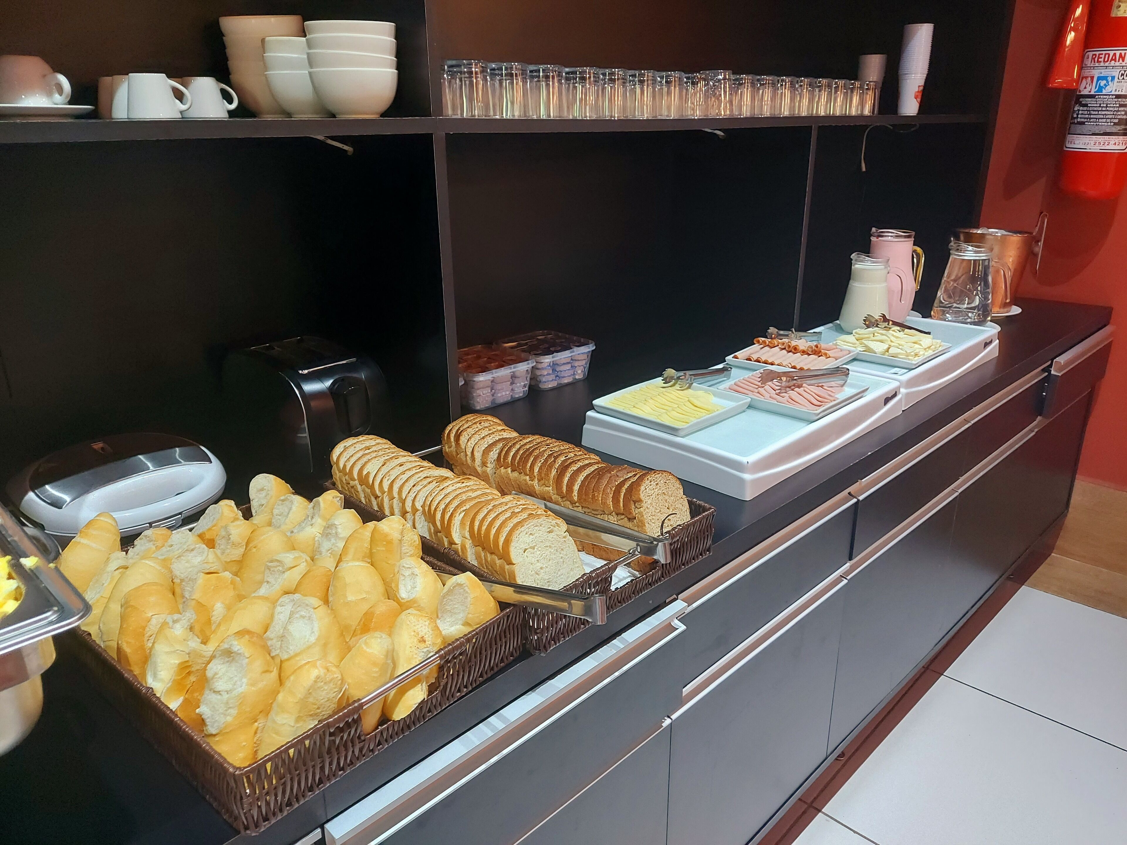 Ein Buffet mit verschiedenen Speisen, darunter Brot, Gebäck und einer Kaffeestation.