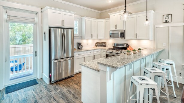 A modern kitchen with white cabinets, stainless steel appliances, and a granite countertop. - Spacious Family and Pet Friendly 30A Home • Walk to Beach, Shops, & Dining (Santa Rosa Beach - Gulf Place 30A)