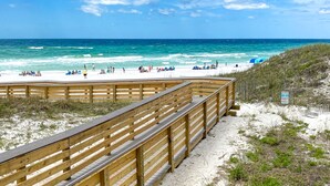 A wooden boardwalk leading to a beach with people sunbathing and swimming. - Spacious Family and Pet Friendly 30A Home • Walk to Beach, Shops, & Dining (Santa Rosa Beach - Gulf Place 30A)
