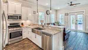 A modern kitchen with stainless steel appliances, white cabinetry, and a large island. - Spacious Family and Pet Friendly 30A Home • Walk to Beach, Shops, & Dining (Santa Rosa Beach - Gulf Place 30A)