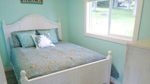 Un dormitorio con cama, ventana y puerta.