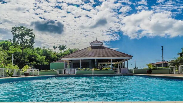 A swimming pool with a covered pavilion in the background. -   Luxury Log Cabin with picturesque Mountain view (Kingston)