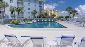 Une piscine dotée de chaises longues et offrant une vue sur un bâtiment d’hôtel.