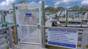 Une zone portuaire où un panneau affiche les règles à respecter par les propriétaires des quais, notamment en ce qui concerne l’accès limité et l’interdiction de se baigner ou de plonger.
