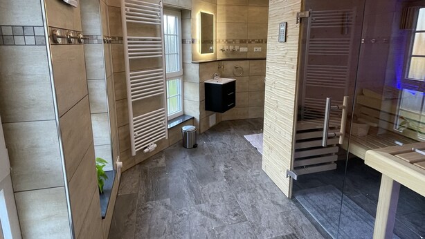 Une salle de bain moderne dotée d’une lucarne, d’un grand miroir et d’une douche à l’italienne.
