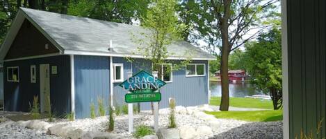 A small cottage with a blue exterior and a sign that reads "Grace Landing Cottages."