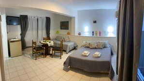 A hotel room with a bed, a desk, a chair, and a small table. - Portillo Apartments (Mendoza)