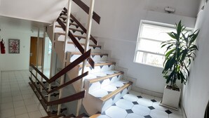 A staircase with wooden handrails and white steps with a geometric pattern. - Portillo Apartments (Mendoza)