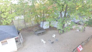 Un espace extérieur clos, aménagé avec un banc, des chaises et une petite table.