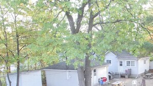 A campsite with several cabins, a picnic table, and a flag.