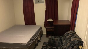 A small, compact room with a single bed, a desk, a chair, and a sofa. - Dock Life Cottage 4 - Riverside, 1 Bedroom, Wasaga (Wasaga Beach)