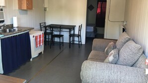 A compact living space with a kitchenette, dining area, and a sofa.