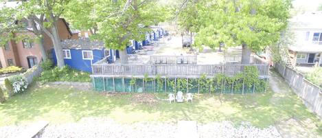 Un barrio residencial con una terraza de madera, piscina y casas con revestimiento azul.