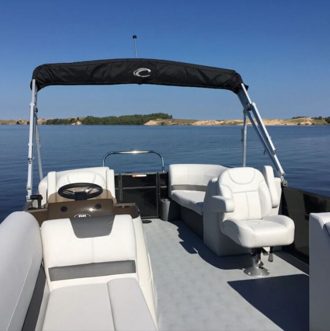 Un barco con toldo, asientos de cuero blanco y timón.
