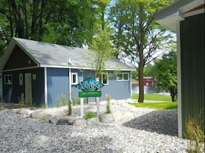 A small cottage with a blue exterior and a sign that reads "Grace Landing Cottages."