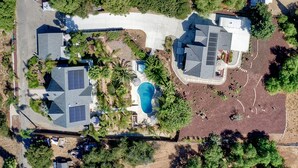 An aerial view of a residential area with two houses, a swimming pool, and surrounding greenery. - Two Homes, One
 Lot Sleeps 18, Pool & Hot Tub Private Villa, 9 miles from beach. (Vista)
