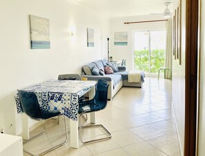 Een moderne woonkamer met een eethoek, een bank en een tafel met stoelen.