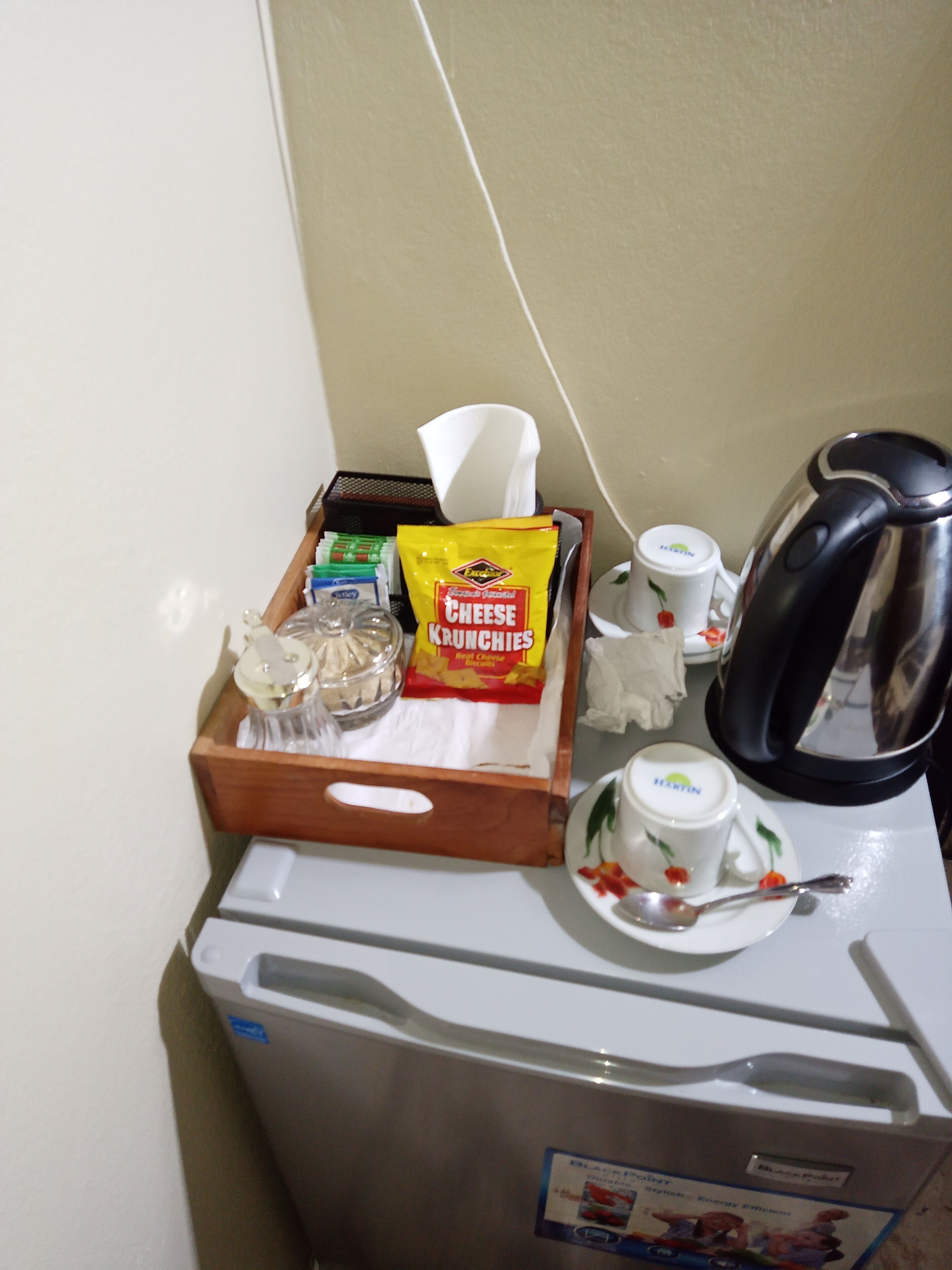 A minibar with snacks, a coffee maker, and a tea set.