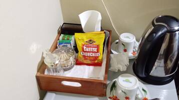 A minibar with snacks, a coffee maker, and a tea set.