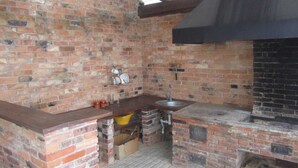 A brick-built outdoor kitchen with a sink, a hanging dish rack, and a chimney. - Cozy guest house near Braslaw lakes (Braslaw)