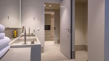 A modern bathroom with a sink, mirror, and towel rack.