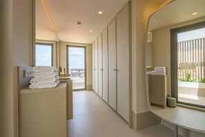 A modern bathroom with a large mirror, a sink, and a towel rack.