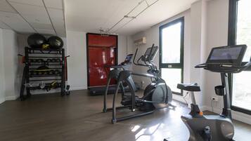 A gym with exercise equipment, a treadmill, and a stationary bike.