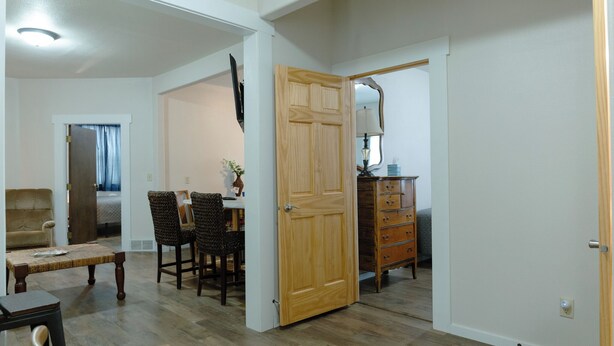 Un salón espacioso con comedor, una puerta de madera y un aparador.