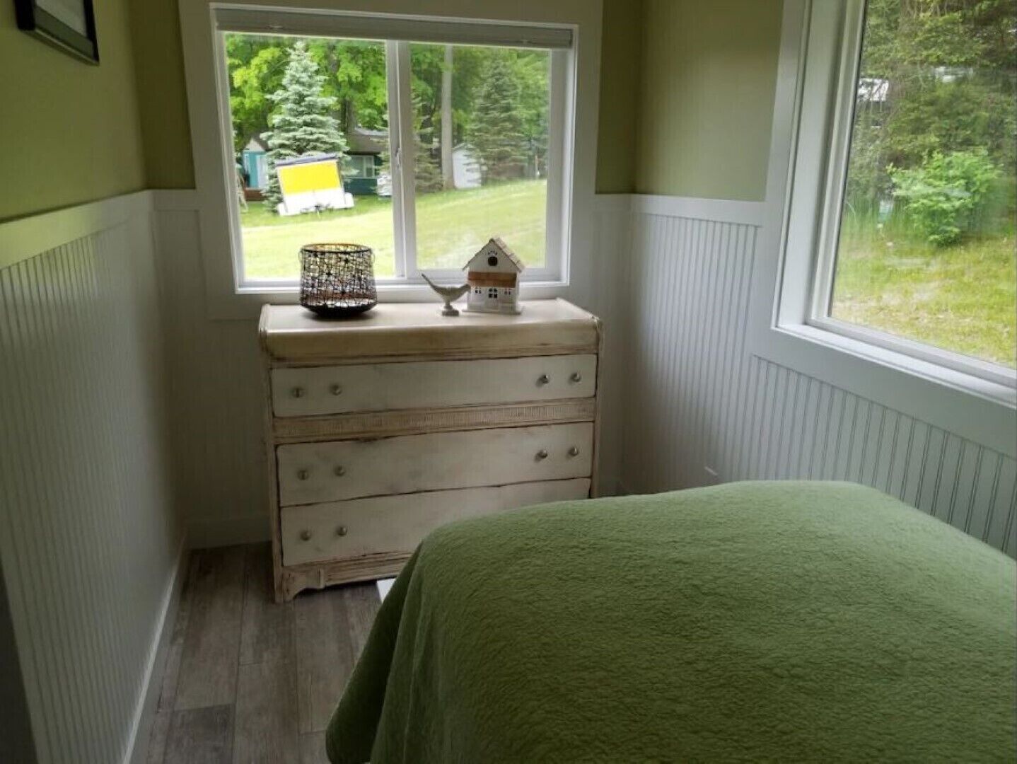 A room with a window, a dresser, and a green towel.