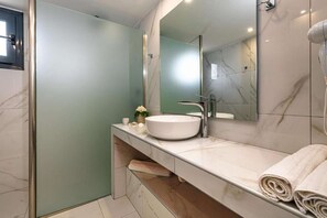 A modern bathroom with a white sink, a large mirror, and a towel rack. - Tortuga  Pelouzo island view I (Vasilikos)
